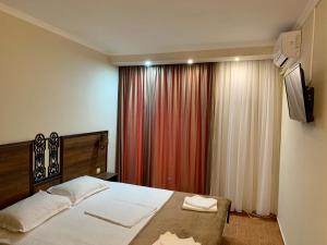 a bedroom with a bed and a red curtain at Hotel Nalba-Dalia Jupiter in Jupiter
