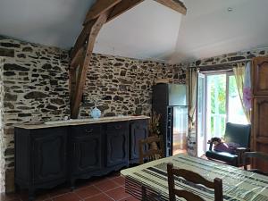 un soggiorno con un muro in pietra e un tavolo di Maison chaleureuse à Bagnac-sur-Célé 70 m² avec jardin accueillant a Linac Altre 4 foto