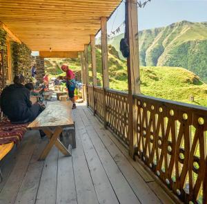 a group of people sitting on the porch of a cabin at Guesthouse Kvavlo in Kvavlo