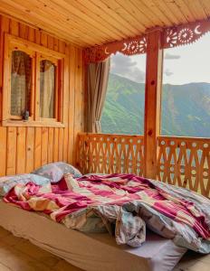 a bed in a wooden room with a large window at Guesthouse Kvavlo in Kvavlo