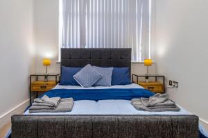 - une chambre dotée d'un grand lit avec des draps et des oreillers bleus dans l'établissement 10080 Luxury Apartment near Luton town Mall, à Luton