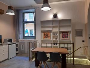- une cuisine avec une table et deux chaises dans une pièce dans l'établissement Central Garibaldi Loft, a piedi a Palazzo Reale, à Turin