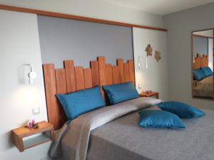 a bedroom with a large bed with blue pillows at Hotel - Résidence Habitation Grande Anse in Deshaies +125 photos