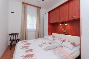 sypialnia z łóżkiem z drewnianym zagłówkiem w obiekcie Apartments Branka w mieście Mošćenička Draga