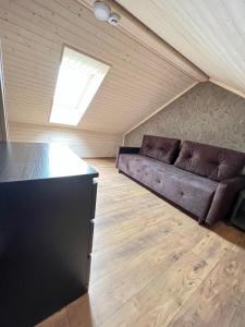 a living room with a couch in a attic at Kuršių Take in Šventoji +13 photos
