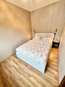 a bedroom with a bed and a wooden floor at Kuršių Take in Šventoji