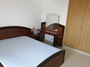 Schlafzimmer mit einem Bett, einer Kommode und einem Spiegel in der Unterkunft S+1 vue mer climatisé in Chott Meriem