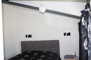 1 dormitorio con cama y pared blanca en Квартира-студия в ЖК Ботанический сад 10 мкр, en Aktau