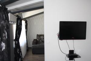 telewizor z płaskim ekranem wiszący na ścianie w salonie w obiekcie Квартира-студия в ЖК Ботанический сад 10 мкр w mieście Aktau