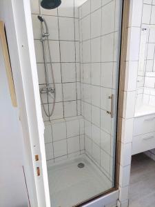 a shower with a glass door in a bathroom at Appartement confortable à Rosny-sous-Bois, 38m² + Vue sur la ville in Rosny-sous-Bois +6 photos