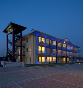 un gran edificio con luces encendidas por la noche en Hotel Rivus, en Peschiera del Garda