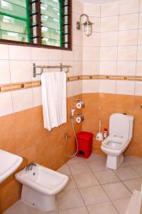 a bathroom with a toilet and a sink at Kahama Hotel Mombasa in Bamburi