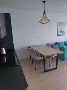 - une salle à manger avec une table, des chaises et un canapé dans l'établissement Apartament Blu Amber, à Sarbinowo