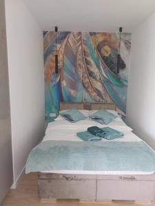 Schlafzimmer mit einem Bett mit Wandgemälde in der Unterkunft Apartament Blu Amber in Sarbinowo