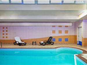 uma piscina com duas cadeiras e uma piscina em Aparthotel Adagio Access Poitiers em Poitiers