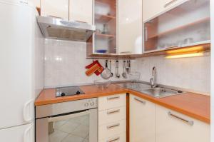 a kitchen with white cabinets and a sink at House Anima in Maslinica +40 photos