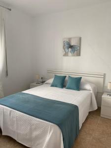 a bedroom with a large bed with blue pillows at La Casa de Manolo in Bolonia