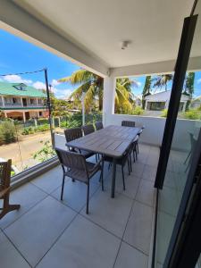 uma mesa e cadeiras num pátio com vista para o oceano em Appartement neuf à Trou aux Biches em Trou-aux-Biches