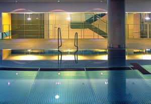 a swimming pool with two chairs in a building at Hotel Kö59 Düsseldorf - Member of Hommage Luxury Hotels Collection in Düsseldorf