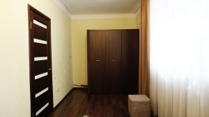 um corredor com uma porta castanha e uma cadeira num quarto em Doba In Ua Lux Apartments em Dnipro