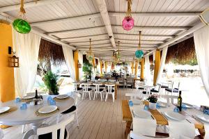 een restaurant met witte tafels, stoelen en verlichting bij Moon Beach&Hotel in Bodrum City