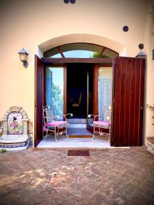 een open deur naar een patio met 2 stoelen bij Appartamento Paolo & Francesca in Verucchio