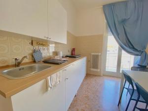 uma cozinha com um lavatório e uma cortina azul em Guest House Service - Modugno em Modugno
