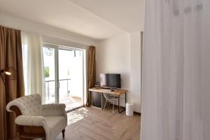 a living room with a chair and a desk and a window at Moon Beach&Hotel in Bodrum City