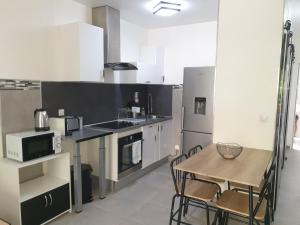 uma cozinha com uma mesa de madeira, uma mesa e cadeiras em Beau studio / Clim / Parking / Plage à 200 m em San-Martino-di-Lota