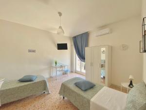 a bedroom with two beds and a television in it at Guest House Service - Modugno in Modugno