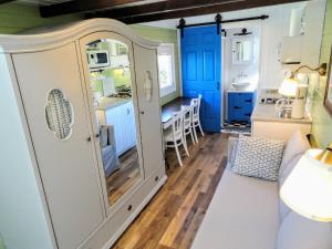 a kitchen with blue cabinets and a dining room at Tiny Glamping Holiday Houses in Ercsi