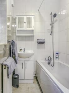 a white bathroom with a sink and a bath tub at 090 Luxury 1 bedroom flat near Luton Town and station in Luton