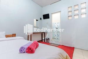 a bedroom with two beds and a window at Nafisa Homestay Syariah Near Jatim Park 3 Batu Mitra RedDoorz in Malang
