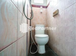 a bathroom with a toilet and a shower at Nafisa Homestay Syariah Near Jatim Park 3 Batu Mitra RedDoorz in Malang +23 photos