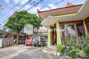a street with cars parked in front of a building at Nafisa Homestay Syariah Near Jatim Park 3 Batu Mitra RedDoorz in Malang