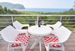 a white table and chairs on a balcony with the ocean at Apartments Siljak in Petrovac na Moru