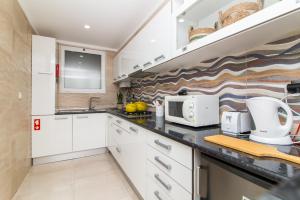 uma cozinha com armários brancos e um micro-ondas em Açoteias B3 em Albufeira