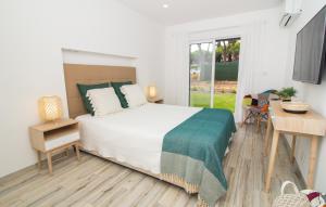 a bedroom with a bed and a desk and a window at Açoteias B3 in Albufeira