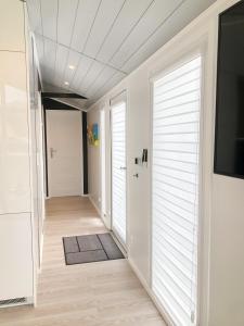 einen Flur mit weißen Wänden und Türen und einem TV in der Unterkunft Luxus Ferien-Lodge Lurger-Fasching in Rohrbach An Der Gölsen