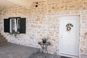 ZatonにあるApartment Magdalenaの白い扉とテーブルの石壁