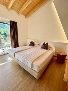 um quarto com uma cama grande e uma janela grande em Agriturismo Terre di Ginepro em Borghetto di Vara