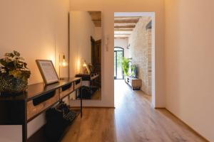 a living room with a wooden floor and a brick wall at Bravissimo Plaça de la Independència Garden View, with large terrace in Girona