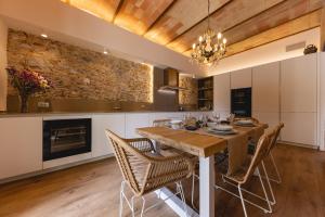 a kitchen with a dining room table and chairs at Bravissimo Plaça de la Independència Garden View, with large terrace in Girona