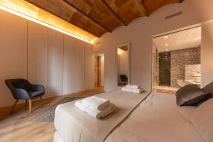 a bedroom with a large bed with towels on it at Bravissimo Plaça de la Independència Garden View, with large terrace in Girona