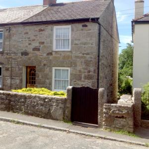 an old stone house with a gate in front of it at 3 bedroom Grade II Listed Holiday Cottage in Saint Erth
