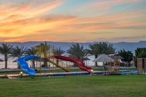 a playground with two slides in a park at Grand Tala Bay Resort Aqaba in Aqaba