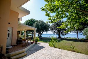 un porche de una casa con vistas al agua en Kiani Akti Villas, en Preveza