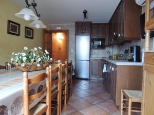 a kitchen with wooden cabinets and a kitchen with a refrigerator at Casa La Mercedes in Ballobar