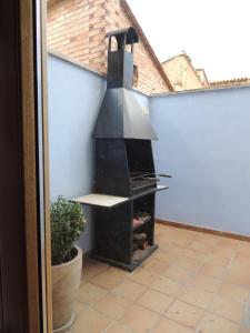 una parrilla al aire libre en una habitación con una pared azul en Casa La Mercedes, en Ballobar