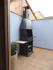 an outdoor grill in a room with a blue wall at Casa La Mercedes in Ballobar